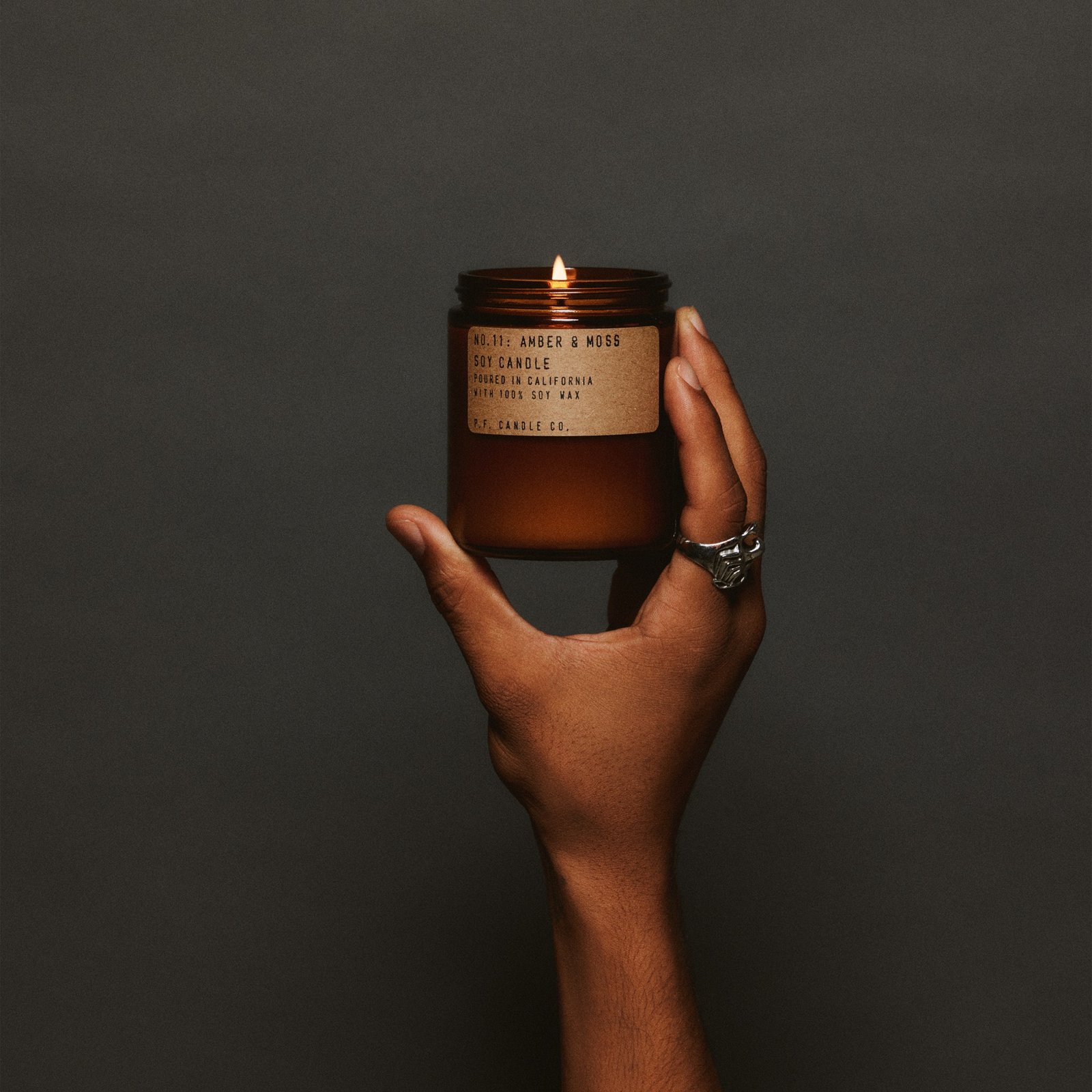 P.F. Candle Co. No.11 琥珀苔蘚香氛蠟燭點燃後透出暖光